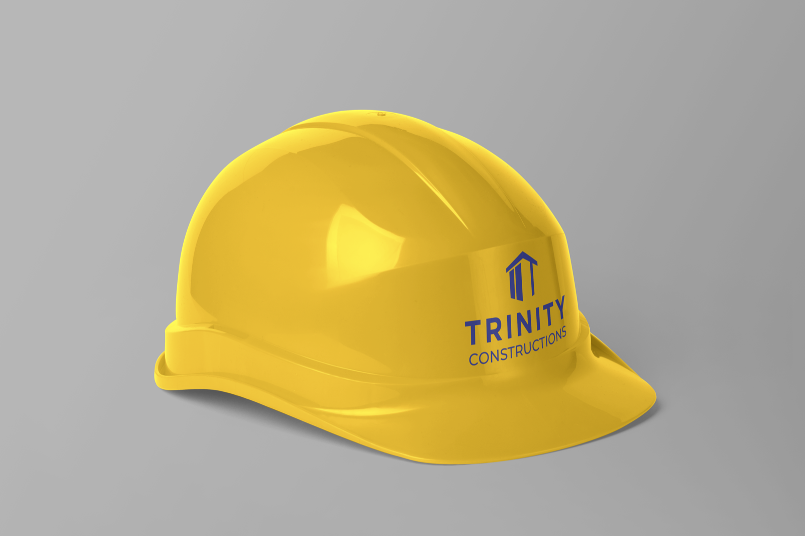Trinity Constructions logo shown on a yellow construction helmet mockup